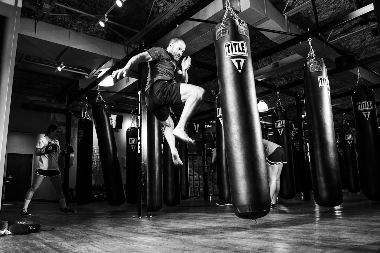 about-04 Action-packed scene of a man training in a gym with punching bags.